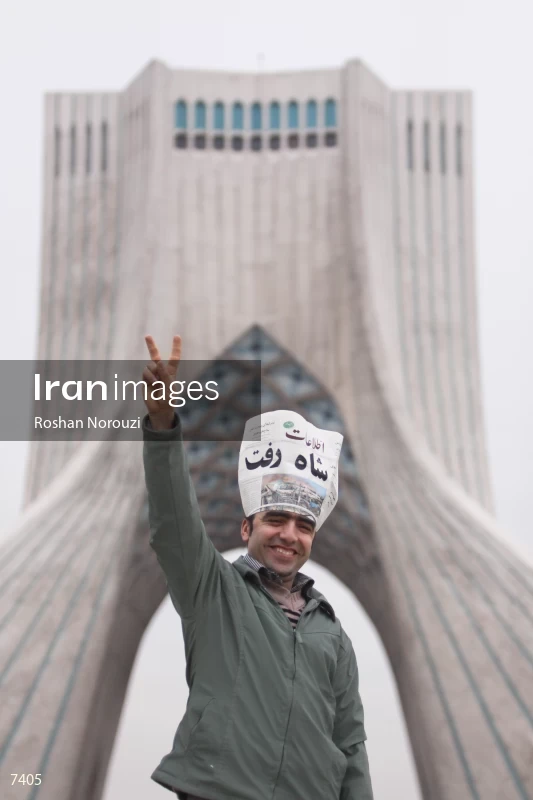 Iranian man shows the victory sign in front of Azadi tower