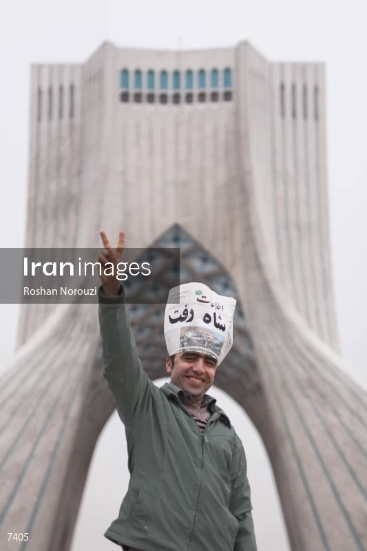 Iranian man shows the victory sign in front of Azadi tower